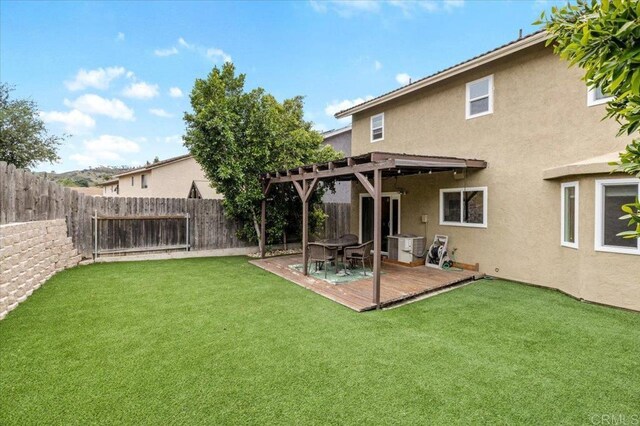 back of property featuring stucco siding, a pergola, and a wooden deck