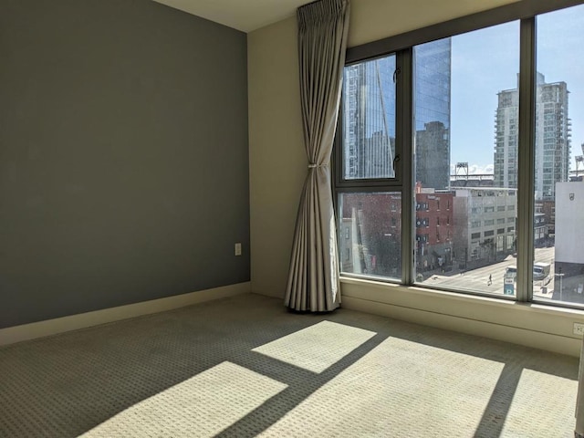 carpeted empty room featuring healthy amount of natural light and a city view