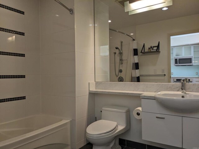 bathroom featuring toilet, vanity, and shower / bathtub combination with curtain