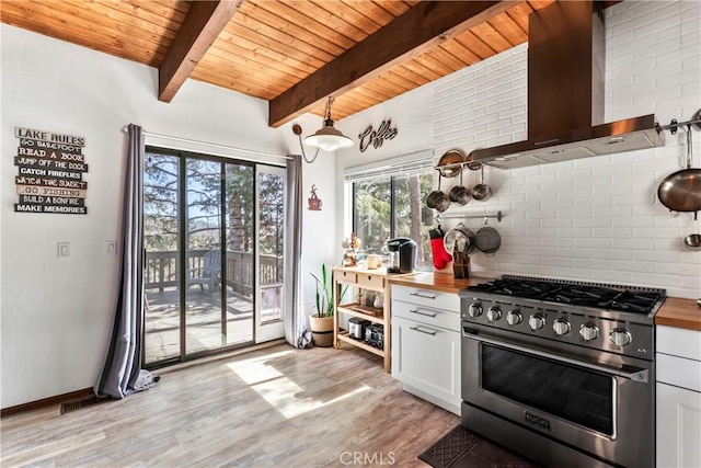 kitchen with high end stainless steel range oven, wall chimney exhaust hood, open shelves, wood counters, and decorative backsplash