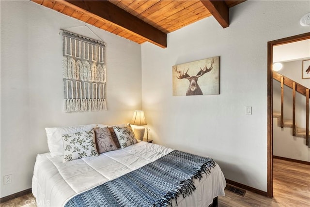 bedroom featuring wooden ceiling, baseboards, and wood finished floors