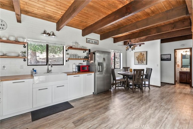 kitchen featuring stainless steel fridge, a sink, wood counters, open shelves, and wood ceiling