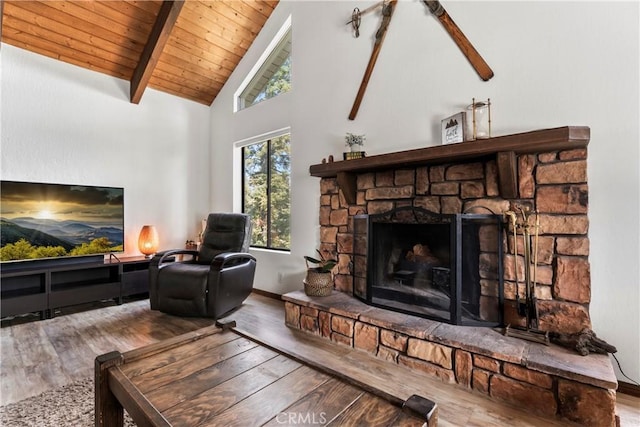 living room featuring hardwood / wood-style flooring, a stone fireplace, beamed ceiling, wooden ceiling, and high vaulted ceiling
