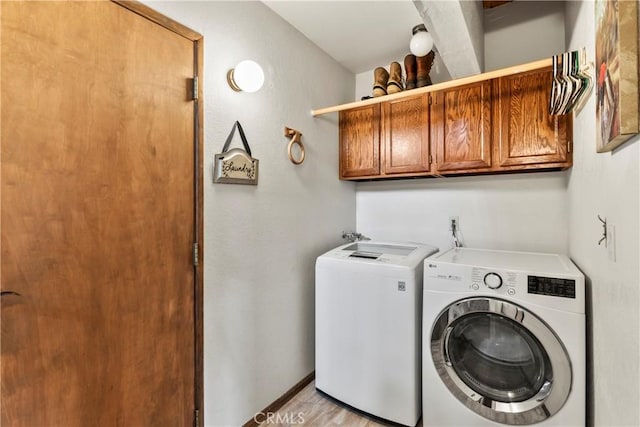laundry area with independent washer and dryer, cabinet space, and baseboards