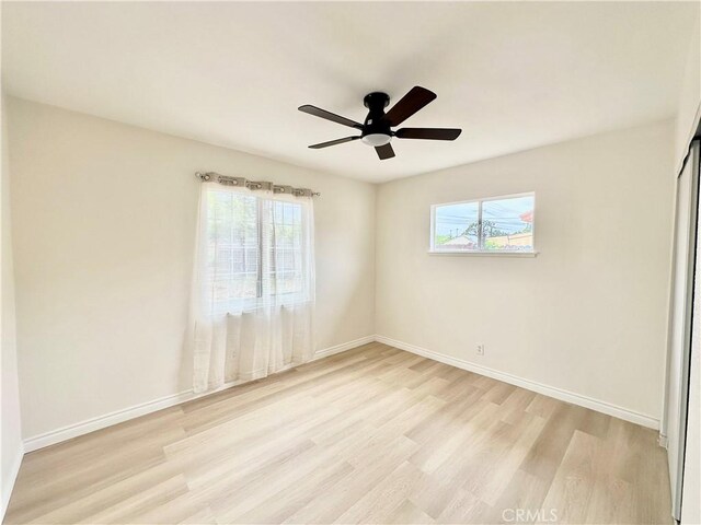 unfurnished bedroom featuring light wood-type flooring, baseboards, and ceiling fan