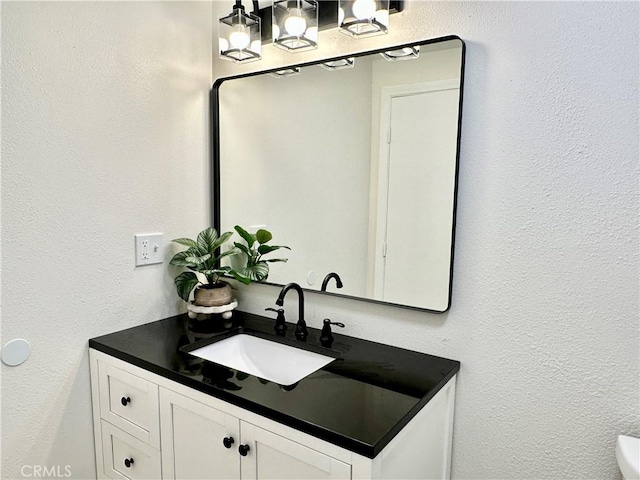 bathroom featuring vanity and a textured wall