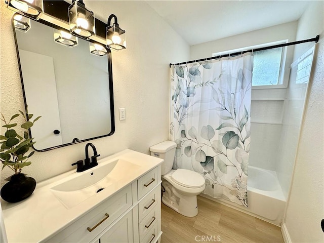 bathroom featuring wood finished floors, toilet, vanity, shower / bath combination with curtain, and a chandelier