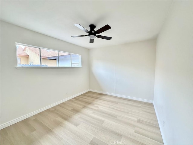 spare room featuring a ceiling fan, wood finished floors, and baseboards