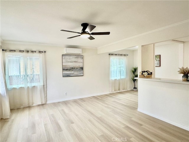 empty room featuring a wall unit AC, ceiling fan, ornamental molding, light wood-type flooring, and baseboards