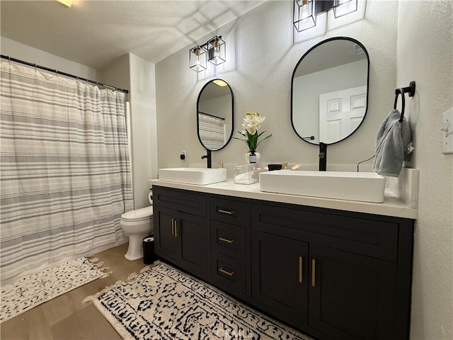 23 Ponte Sonata, Lake Elsinore, CA 92532 - full bath with toilet, double vanity, wood finished floors, a textured wall, and a shower with shower curtain