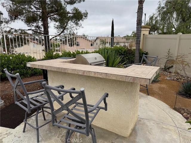 23 Ponte Sonata, Lake Elsinore, CA 92532 - view of patio featuring fence, exterior kitchen, and grilling area