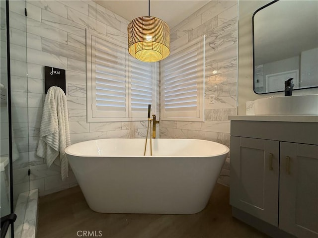 23 Ponte Sonata, Lake Elsinore, CA 92532 - full bath with tile walls, vanity, a freestanding tub, and wood finished floors