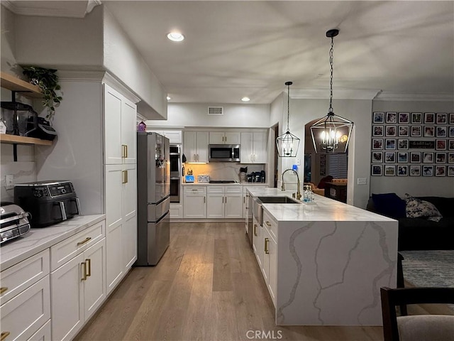 23 Ponte Sonata, Lake Elsinore, CA 92532 - kitchen with stainless steel appliances, light wood-style floors, white cabinets, crown molding, and recessed lighting