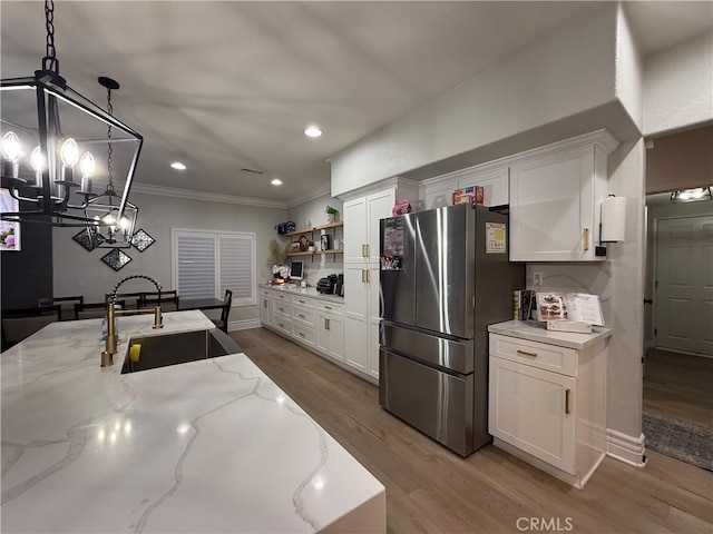 23 Ponte Sonata, Lake Elsinore, CA 92532 - kitchen featuring freestanding refrigerator, a sink, white cabinetry, a chandelier, and crown molding