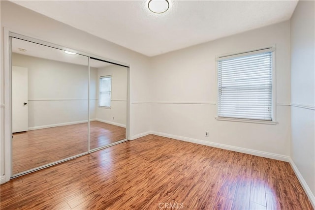 4864 Hersholt Ave, Long Beach, CA 90808 - unfurnished bedroom with wood finished floors, a closet, and baseboards