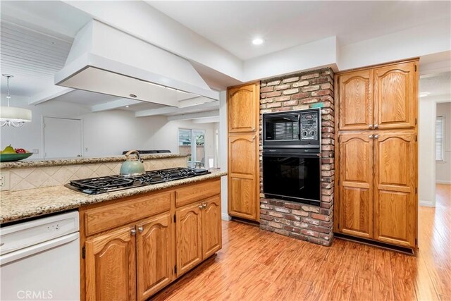 4864 Hersholt Ave, Long Beach, CA 90808 - kitchen featuring black appliances, light wood-style floors, tasteful backsplash, exhaust hood, and light stone countertops