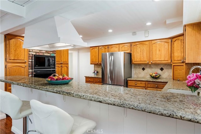 4864 Hersholt Ave, Long Beach, CA 90808 - kitchen with black appliances, a sink, light stone counters, brown cabinets, and recessed lighting