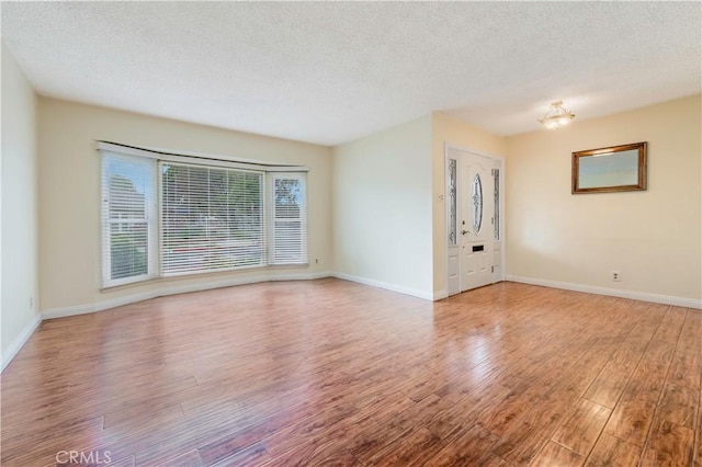 4864 Hersholt Ave, Long Beach, CA 90808 - unfurnished living room with wood finished floors, a textured ceiling, and baseboards