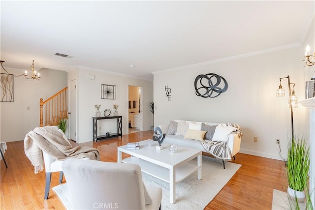 living area with stairs, a chandelier, ornamental molding, light wood-style flooring, and baseboards