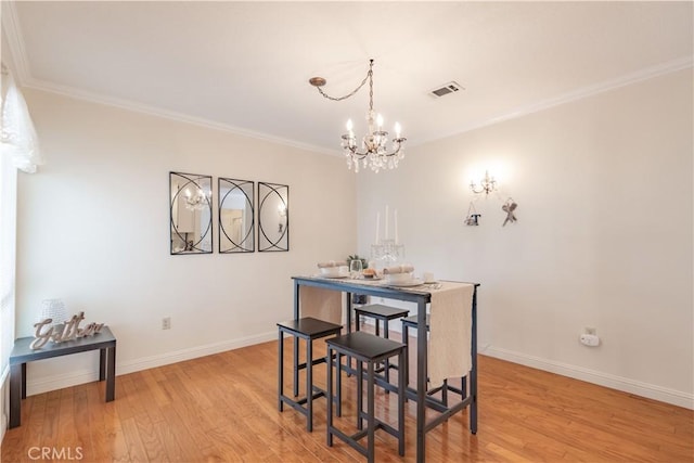 dining area featuring a chandelier, light wood-style floors, ornamental molding, and baseboards