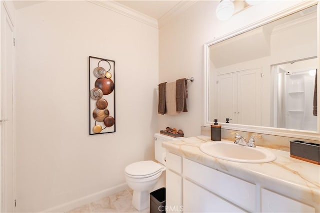 bathroom featuring crown molding, toilet, vanity, and baseboards
