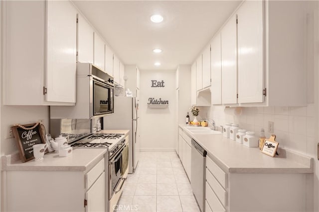 kitchen with gas range oven, a sink, stainless steel dishwasher, white cabinetry, and light countertops