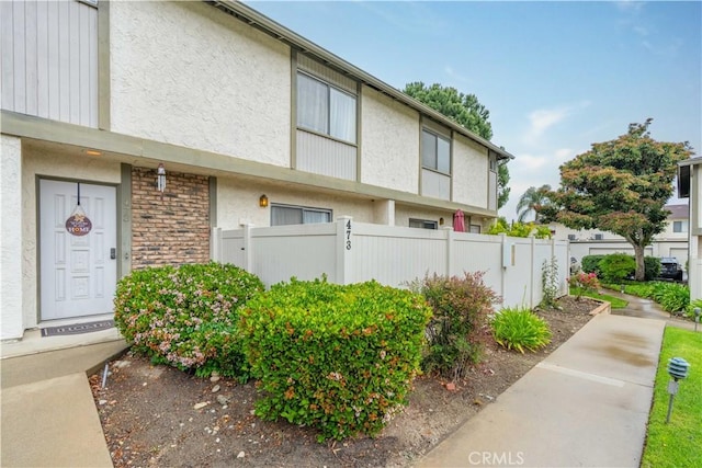 view of front of house with stucco siding and fence