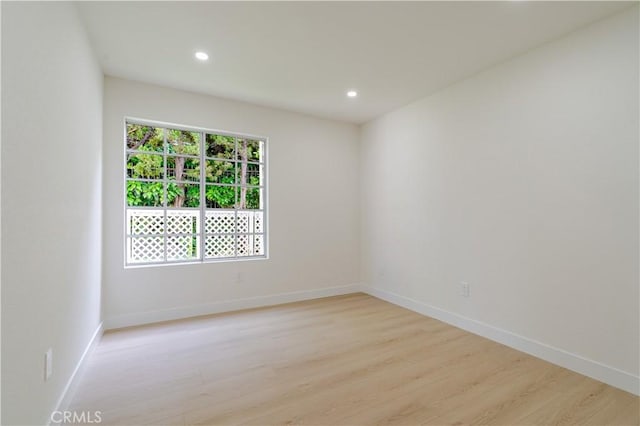 empty room with light wood-style flooring, recessed lighting, and baseboards