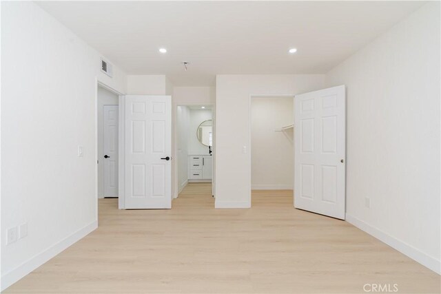 unfurnished bedroom featuring baseboards, light wood-type flooring, and recessed lighting