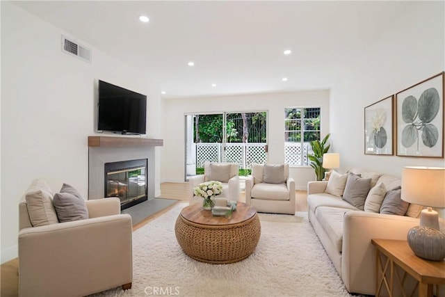 living area featuring recessed lighting and a glass covered fireplace