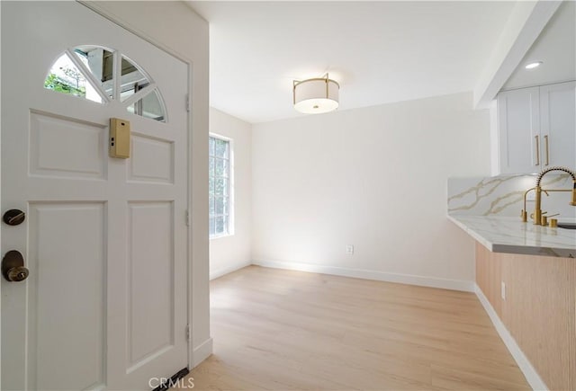 entryway featuring light wood-type flooring and baseboards
