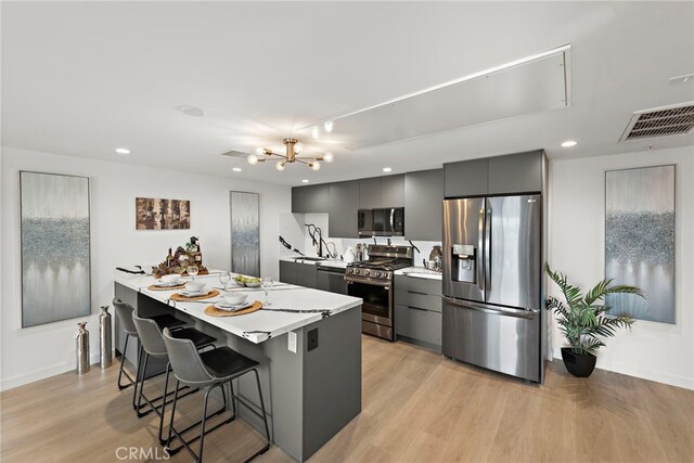 321 S Oxford Ave Unit 603, Los Angeles, CA 90020 - kitchen featuring stainless steel appliances, a kitchen bar, light countertops, baseboards, and recessed lighting