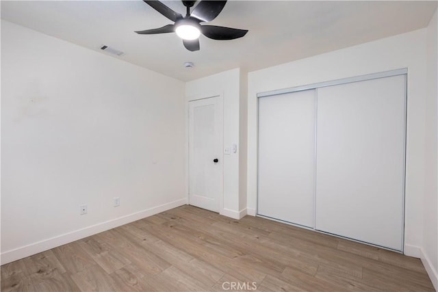 unfurnished bedroom featuring light wood-type flooring, baseboards, a closet, and ceiling fan