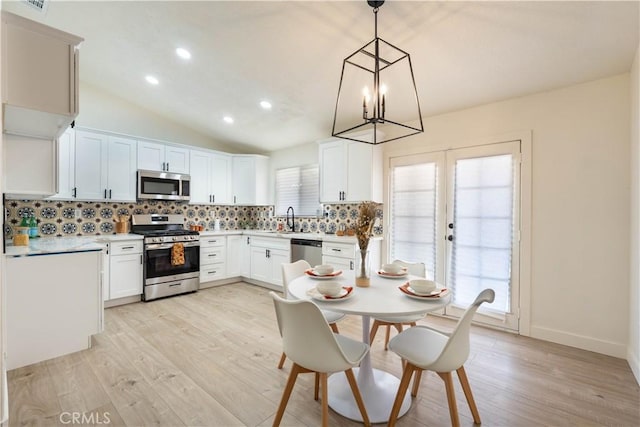 12830 Lakota Rd, Apple Valley, CA 92308 - kitchen featuring stainless steel appliances, light wood finished floors, a chandelier, decorative backsplash, and light countertops