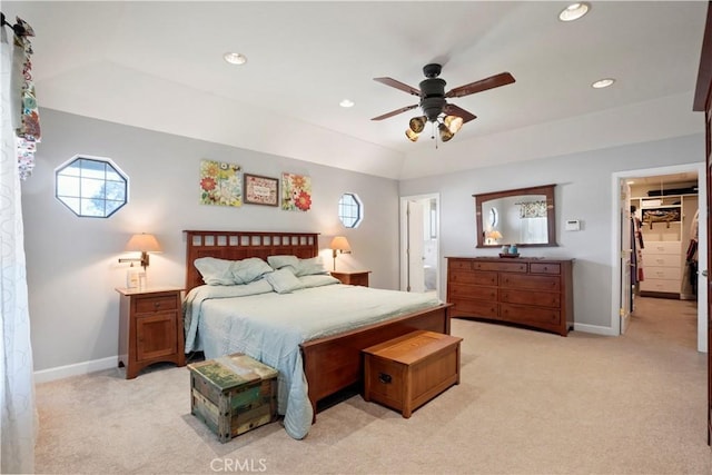 bedroom featuring light colored carpet, a spacious closet, recessed lighting, baseboards, and ceiling fan