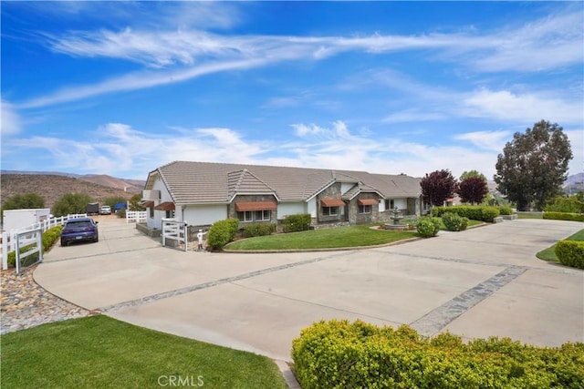 view of front of property with driveway, a tile roof, a mountain view, and stucco siding