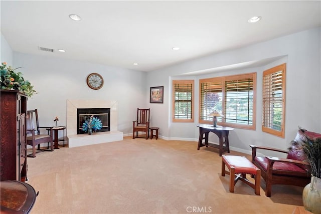 sitting room featuring light carpet, recessed lighting, a premium fireplace, and baseboards