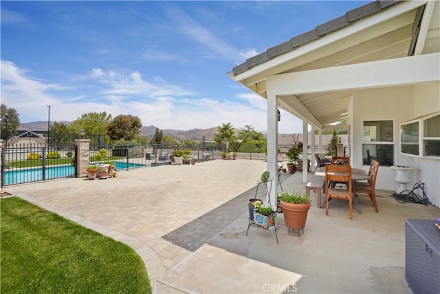 view of patio / terrace with fence and a mountain view
