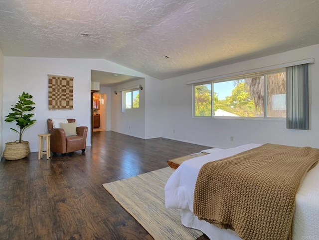 bedroom featuring wood finished floors, lofted ceiling, a textured ceiling, multiple windows, and baseboards