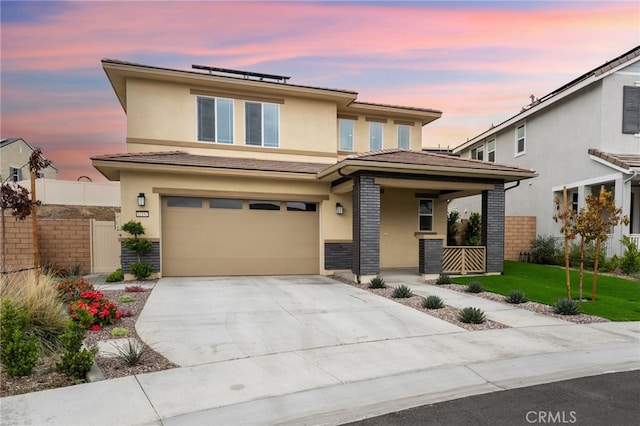 32182 Penstemon Way, Temecula, CA 92591 - prairie-style home with covered porch, a garage, roof mounted solar panels, concrete driveway, and stucco siding