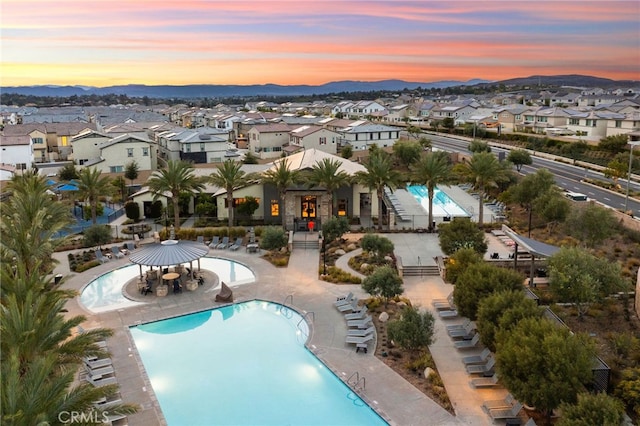 community pool with a residential view, a mountain view, and a gazebo