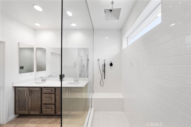 bathroom with a walk in shower, vanity, tile patterned floors, and recessed lighting