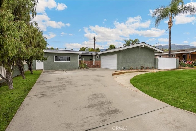 1005 E Woodland Ln, Glendora, CA 91741 - view of front facade featuring stucco siding, driveway, an attached garage, and a mountain view