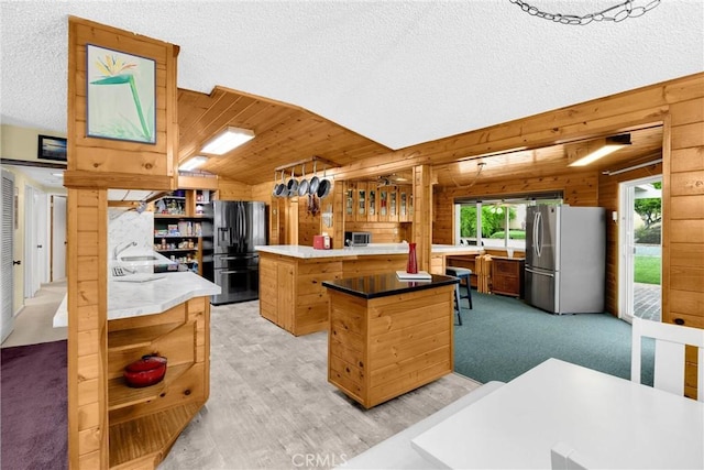 1005 E Woodland Ln, Glendora, CA 91741 - kitchen featuring appliances with stainless steel finishes, a center island, wood walls, open shelves, and a sink