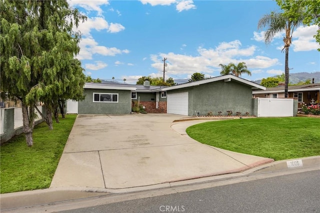 1005 E Woodland Ln, Glendora, CA 91741 - view of front of home with driveway, solar panels, an attached garage, and stucco siding