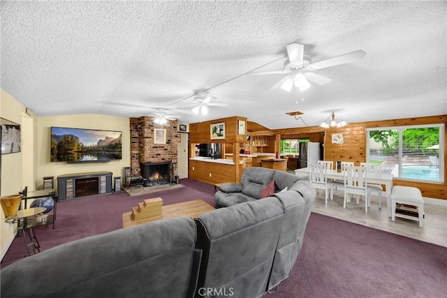 1005 E Woodland Ln, Glendora, CA 91741 - carpeted living room with a fireplace, a textured ceiling, a ceiling fan, lofted ceiling, and wood walls