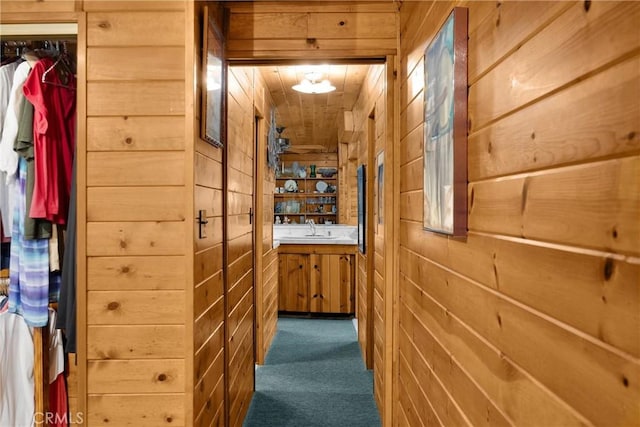 1005 E Woodland Ln, Glendora, CA 91741 - corridor featuring dark colored carpet, wooden walls, and a sink