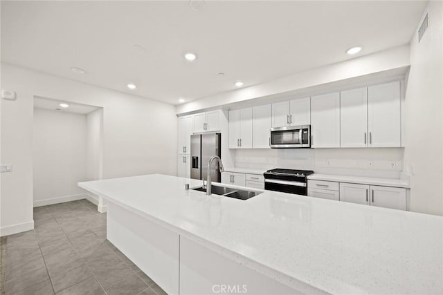 16321 Dawn Way Unit 108, Tustin, CA 92782 - kitchen with stainless steel appliances, a sink, recessed lighting, white cabinets, and light stone countertops