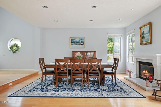 11998 Bubbling Brook St, Moorpark, CA 93021 - dining room with wood finished floors, recessed lighting, baseboards, a glass covered fireplace, and a textured ceiling