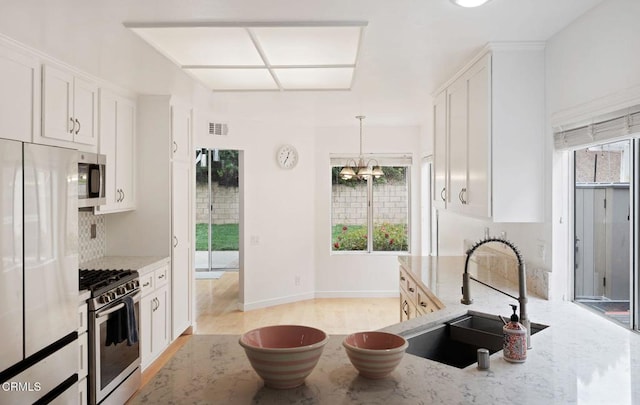 11998 Bubbling Brook St, Moorpark, CA 93021 - kitchen with appliances with stainless steel finishes, a sink, light stone countertops, and plenty of natural light